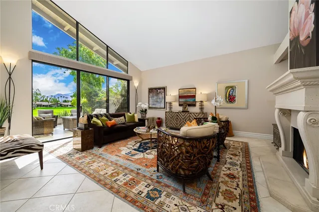 a living room with furniture a fireplace and a large window
