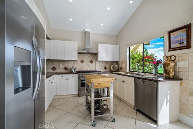 a kitchen with a sink a window and stainless steel appliances
