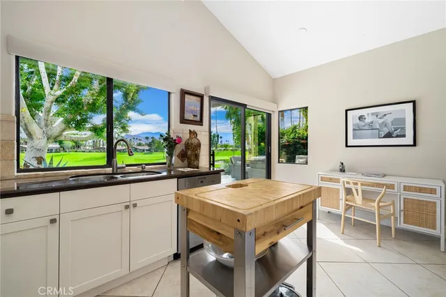 a kitchen with a stove a sink and white cabinets with wooden floors