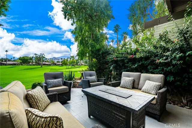 a view of a patio with couches chairs and a yard