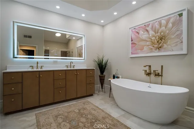 a spacious bathroom with a tub double sink and mirror