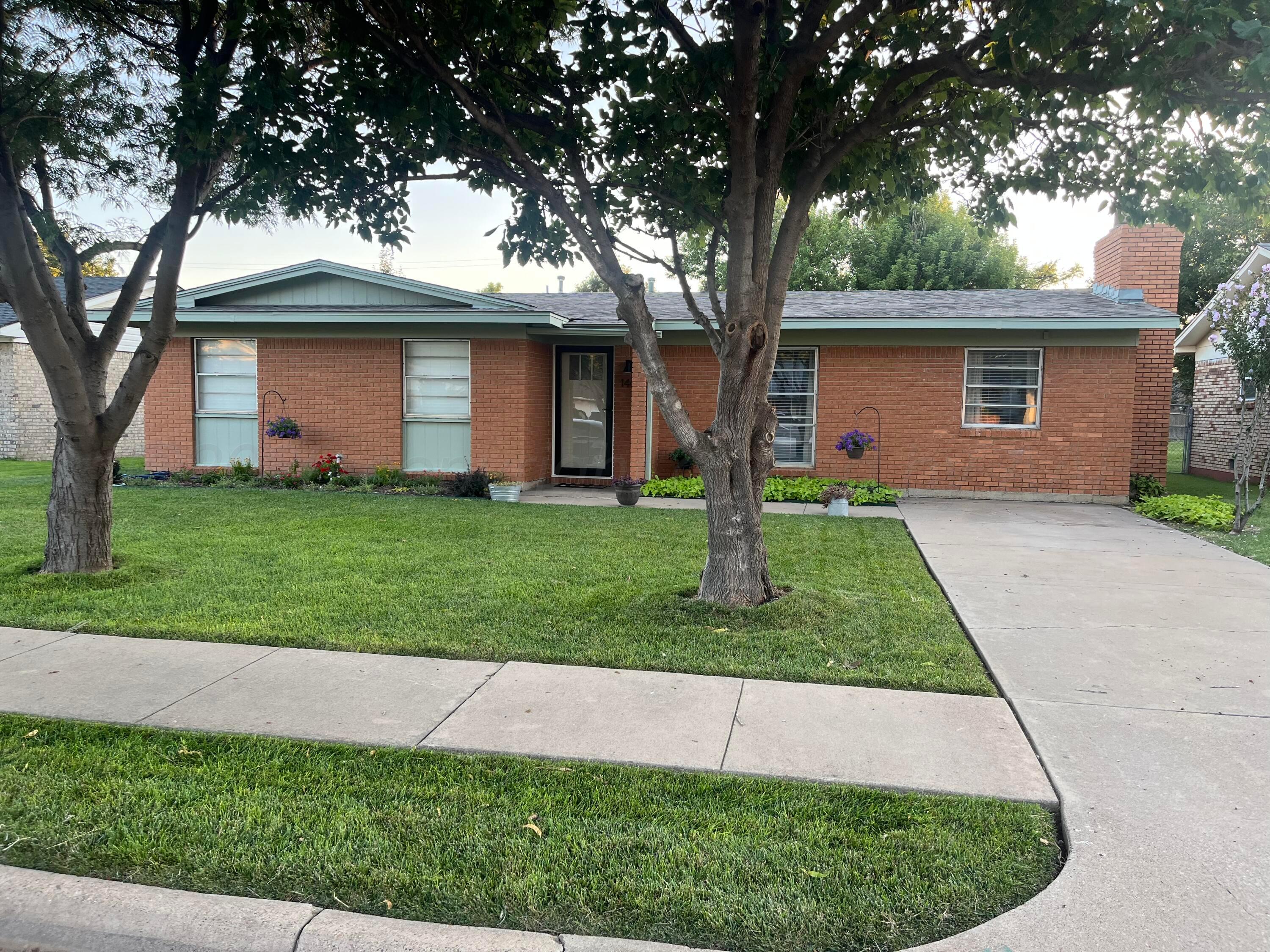 a front view of a house with a yard and tree