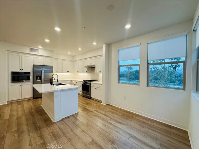 a kitchen with stainless steel appliances kitchen island wooden cabinets and granite counter tops