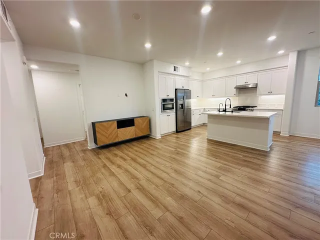 a kitchen with stainless steel appliances kitchen island granite countertop a stove a sink and a refrigerator