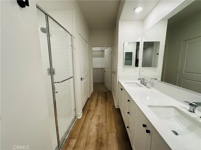 a bathroom with a double vanity sink and mirror with shower