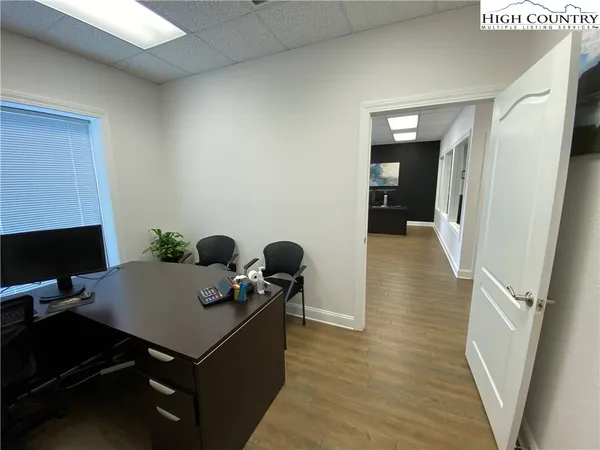 a view of a workspace with furniture and bathroom