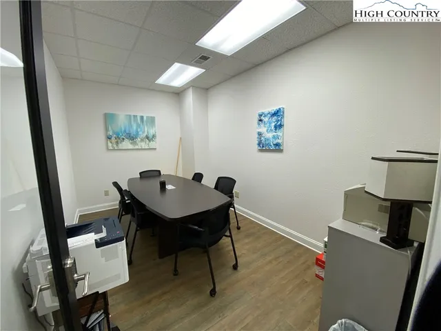 a view of a workspace with furniture and wooden floor