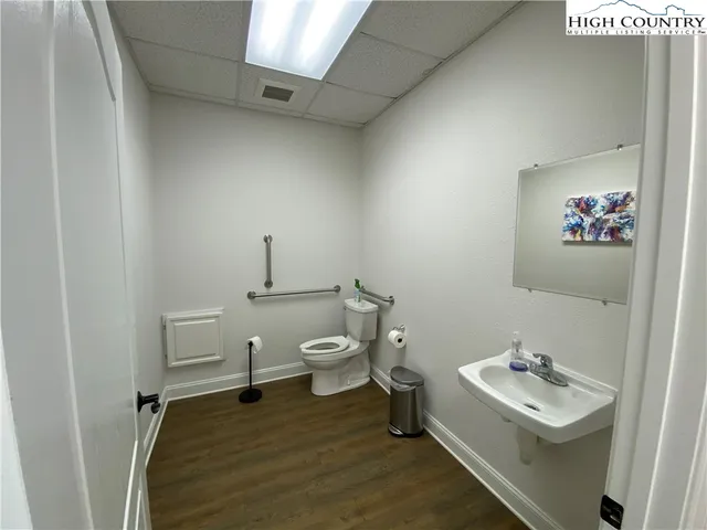 a bathroom with a sink a toilet and a mirror