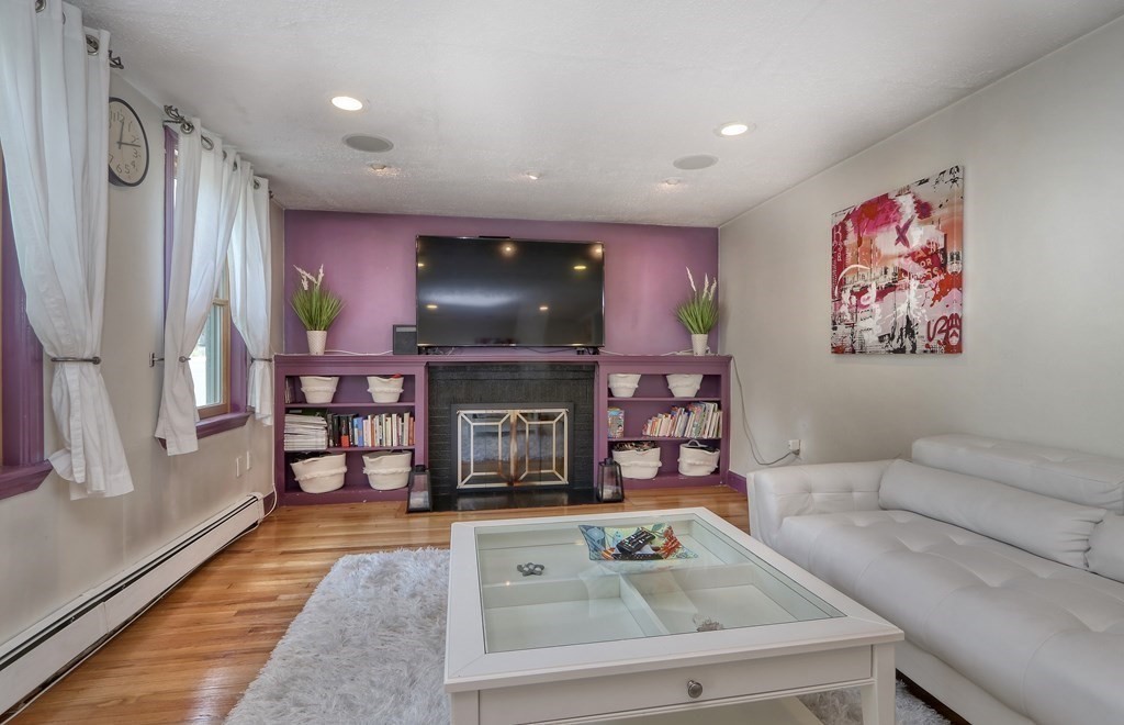 3 Oak Tree Road Dedham, MA 02026 - Photo 4 of 23 a living room with furniture a flat screen tv and a fireplace