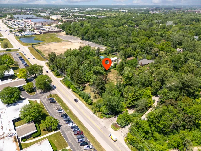 an aerial view of residential houses with outdoor space and trees