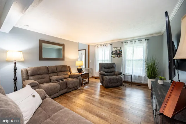 a living room with furniture flat screen tv and wooden floor
