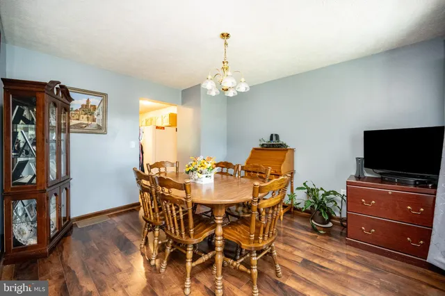 a dining room with furniture a chandelier and wooden floor