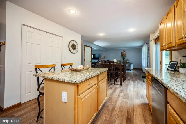 a kitchen with granite countertop a table and chairs in it