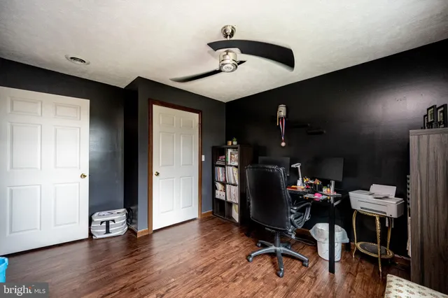 a view of a workspace with furniture and wooden floor