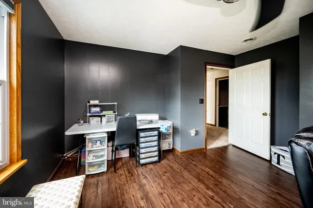 a view of a workspace with furniture and wooden floor