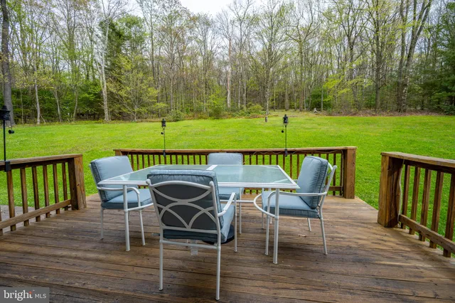 a view of a chairs and table on the wooden deck