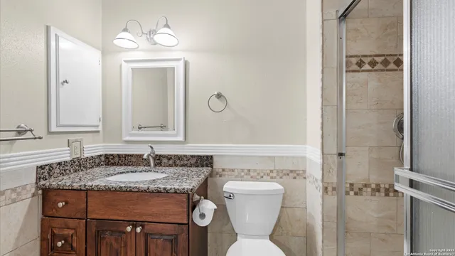 a bathroom with a granite countertop sink toilet and shower