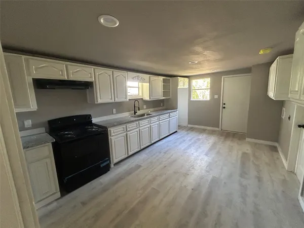 a view of an empty room and window and wooden floor
