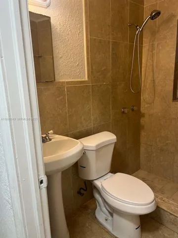 a white toilet sitting next to a bathroom sink
