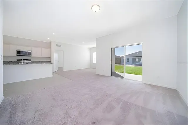 a view of an empty room with a kitchen