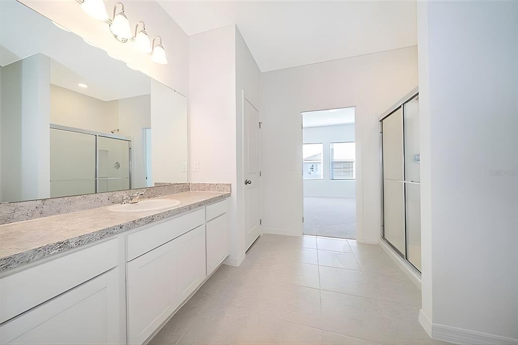5844 Bovine Drive St. Cloud, FL 34771 - Photo 18 of 21 a spacious bathroom with a granite countertop sink a mirror and a