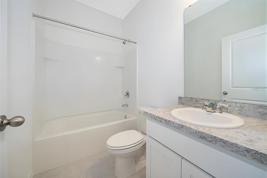 5844 Bovine Drive St. Cloud, FL 34771 - Photo 21 of 21 a bathroom with a granite countertop sink toilet and shower