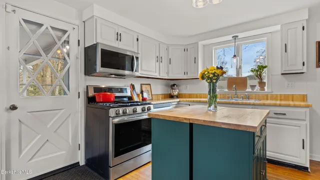 a kitchen with stainless steel appliances granite countertop a sink a stove and a refrigerator