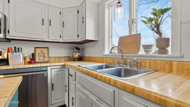 a kitchen with stainless steel appliances granite countertop a sink a stove and cabinets