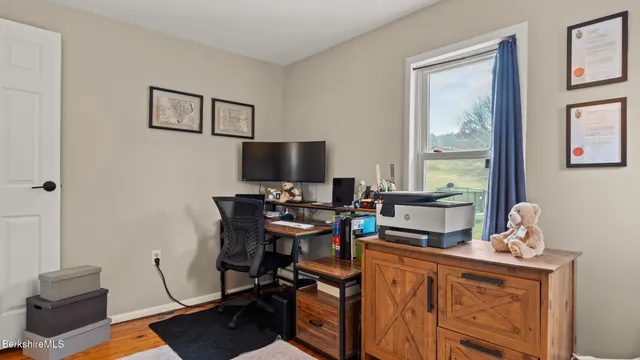 a view of a workspace with furniture and a window