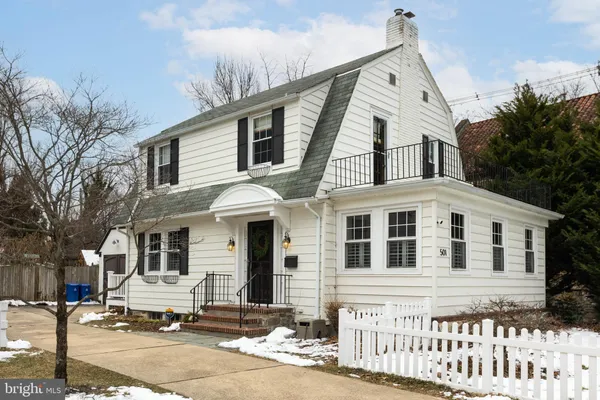 a front view of a house with a tree