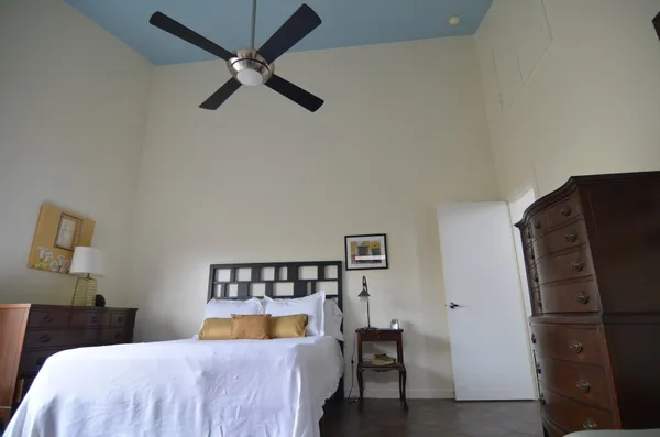 a bedroom with a bed and a refrigerator