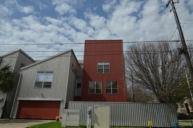 a view of a house with a small yard and wooden fence
