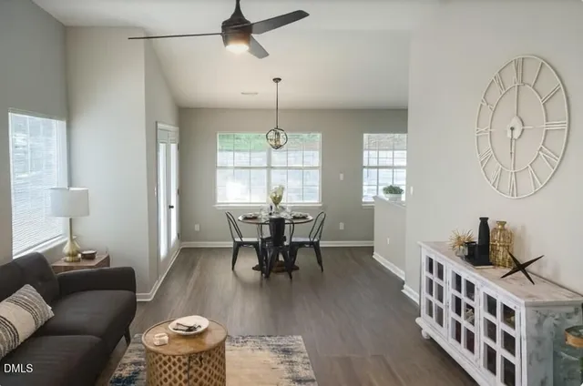 a dining room with wooden floor a chandelier a wooden table and chairs