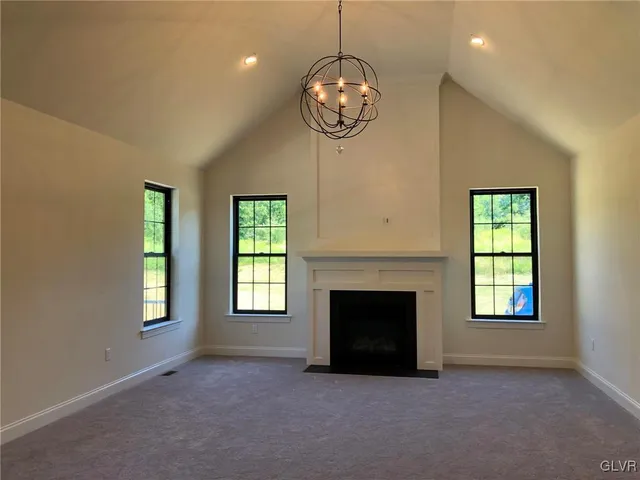 a view of an empty room with a fireplace and a window