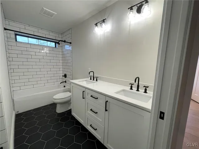 a bathroom with a double vanity sink toilet and shower