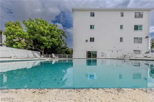 a view of a swimming pool with outdoor seating and plants