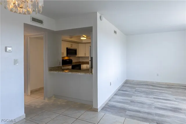 a view of a hallway to room and wooden floor