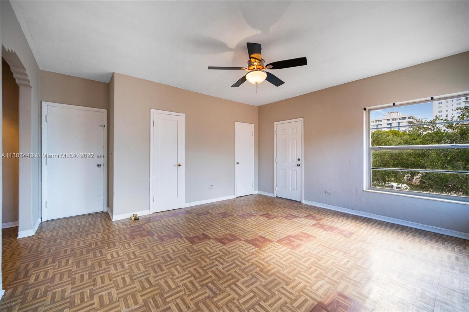 825 Alton Road, Unit 7 Miami Beach, FL 33139 - Photo 3 of 8 a view of empty room with window and ceiling fan