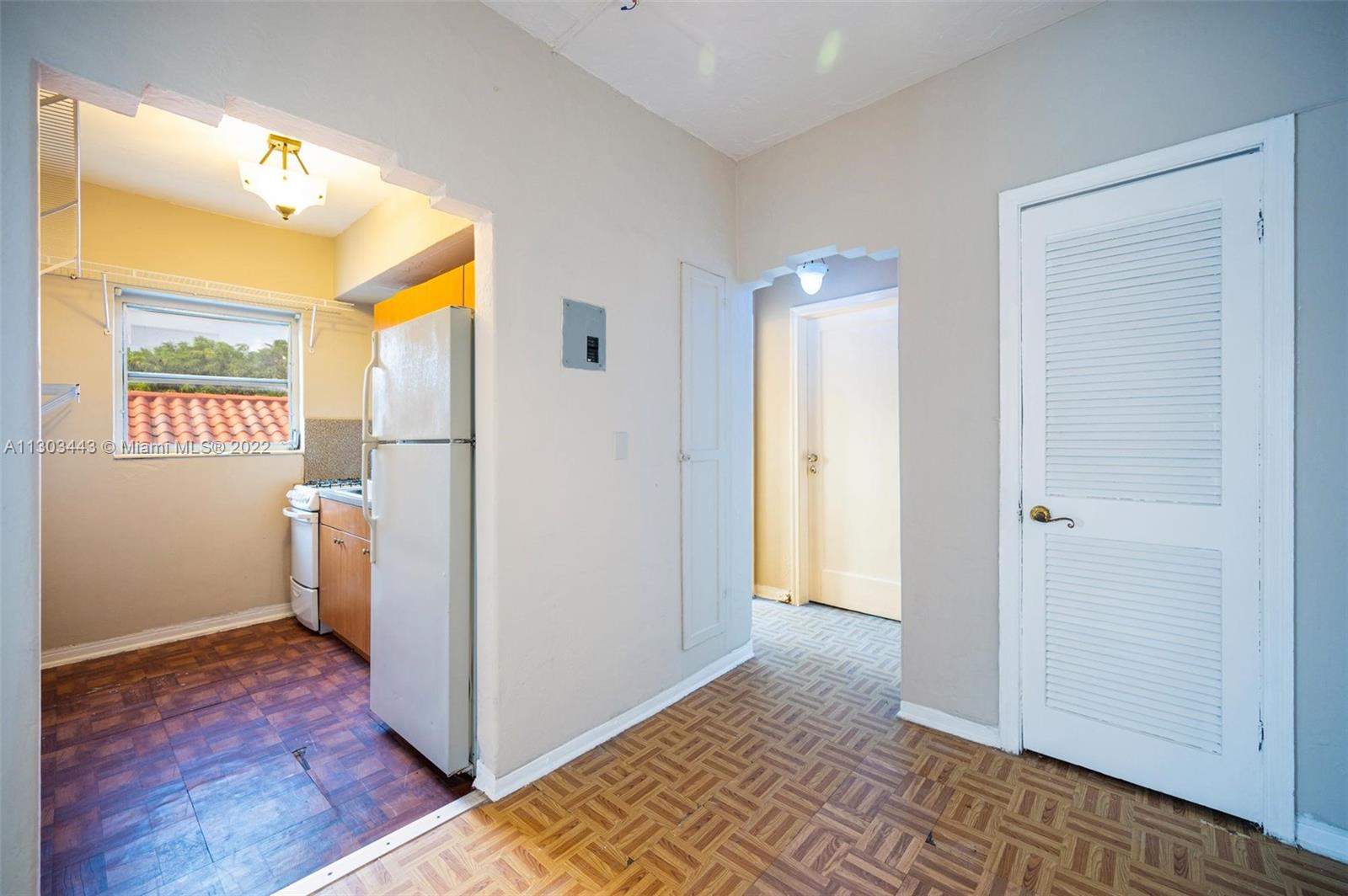 825 Alton Road, Unit 7 Miami Beach, FL 33139 - Photo 6 of 8 a view of a hallway with bathroom and wooden floor