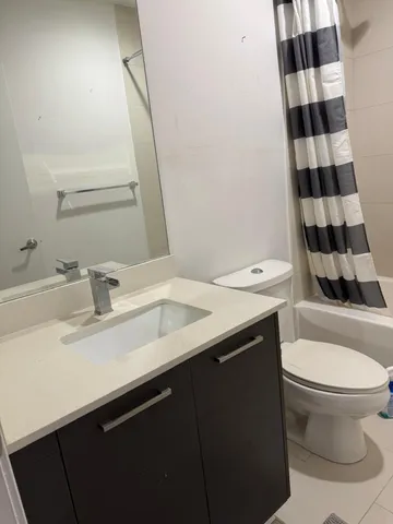 a bathroom with a sink a toilet a shower and a mirror