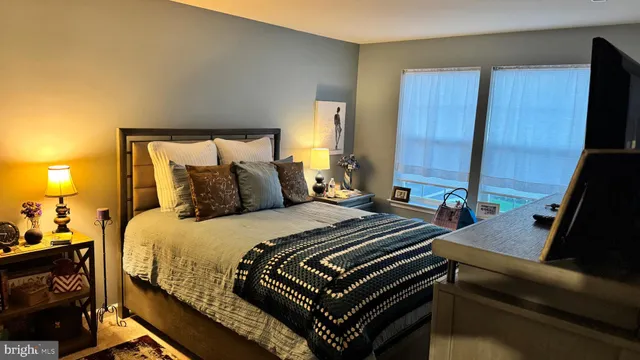 a bedroom with a bed and a flat tv screen on dresser