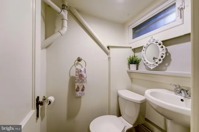 a bathroom with a toilet sink and mirror