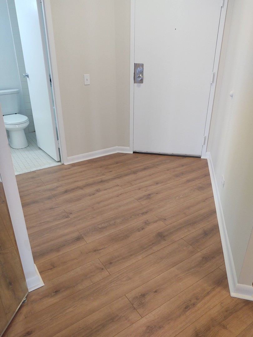5320 North Sheridan Road, Unit 407 Chicago, IL 60640 - Photo 3 of 26 a view of an empty room with wooden floor and a window