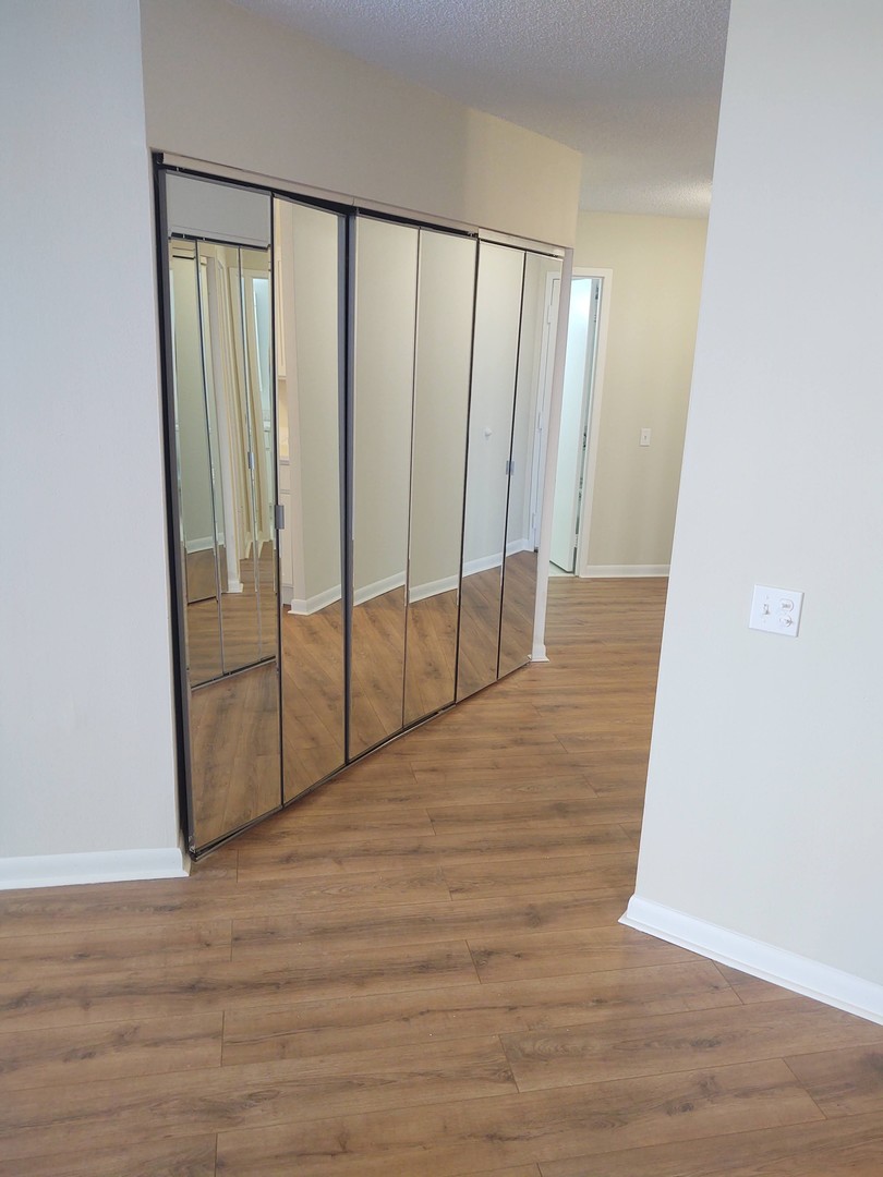 5320 North Sheridan Road, Unit 407 Chicago, IL 60640 - Photo 4 of 26 a view of an empty room with wooden floor