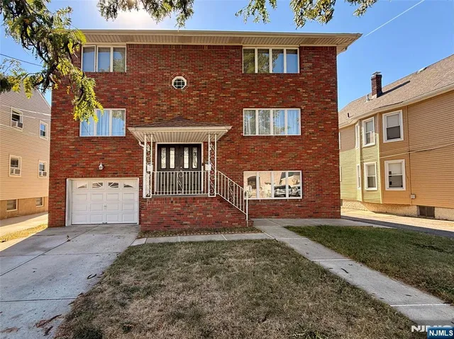 front view of a brick house with a yard