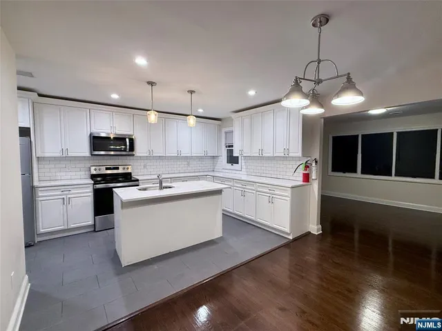 a kitchen with stove a microwave and refrigerator