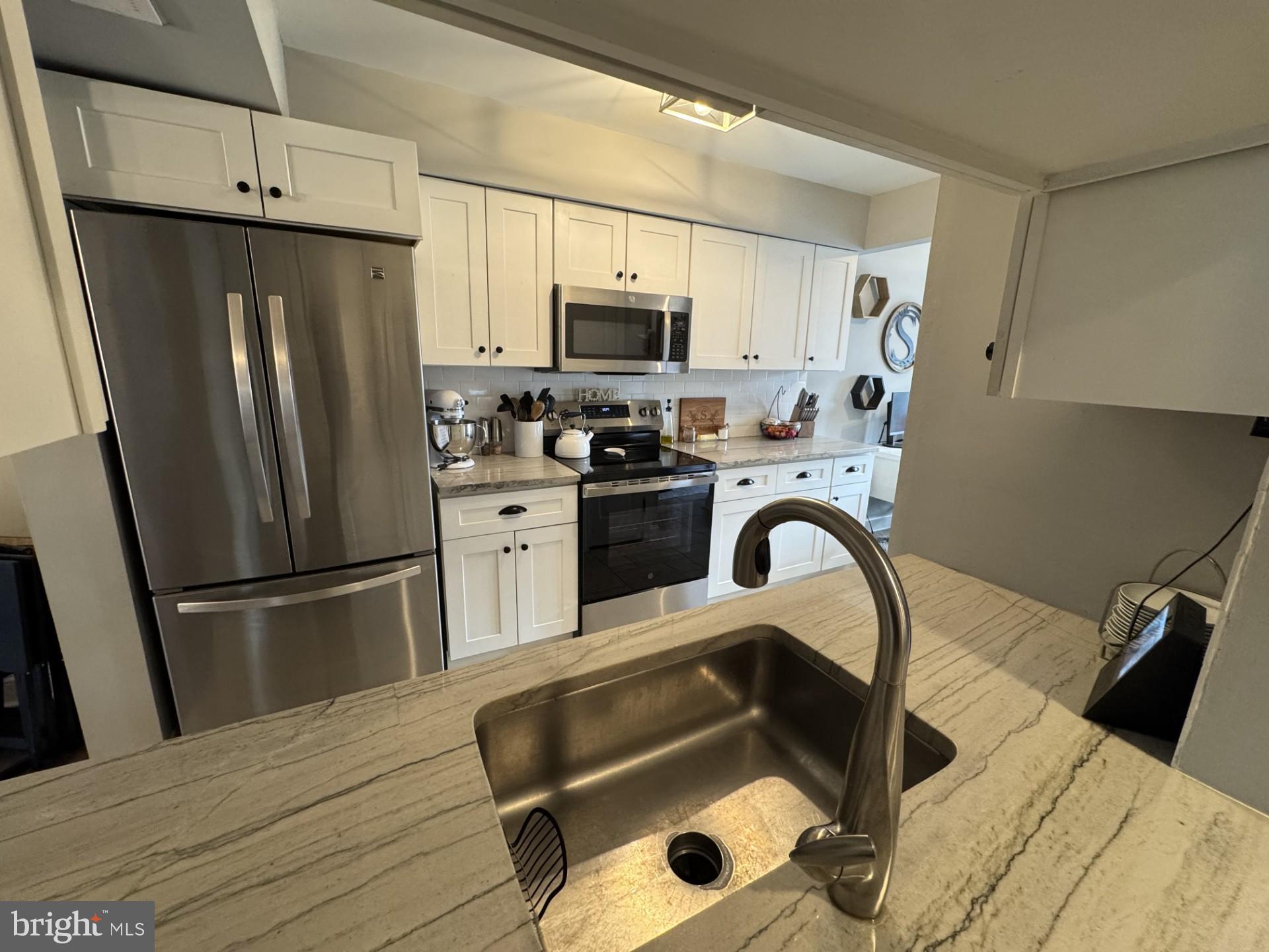 424 Trumbull Court Newtown, PA 18940 - Photo 7 of 21 a kitchen with granite countertop a refrigerator and a stove top oven