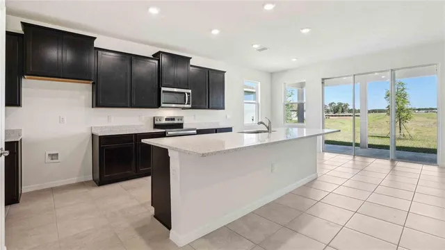 a kitchen with stainless steel appliances kitchen island granite countertop a stove and a sink