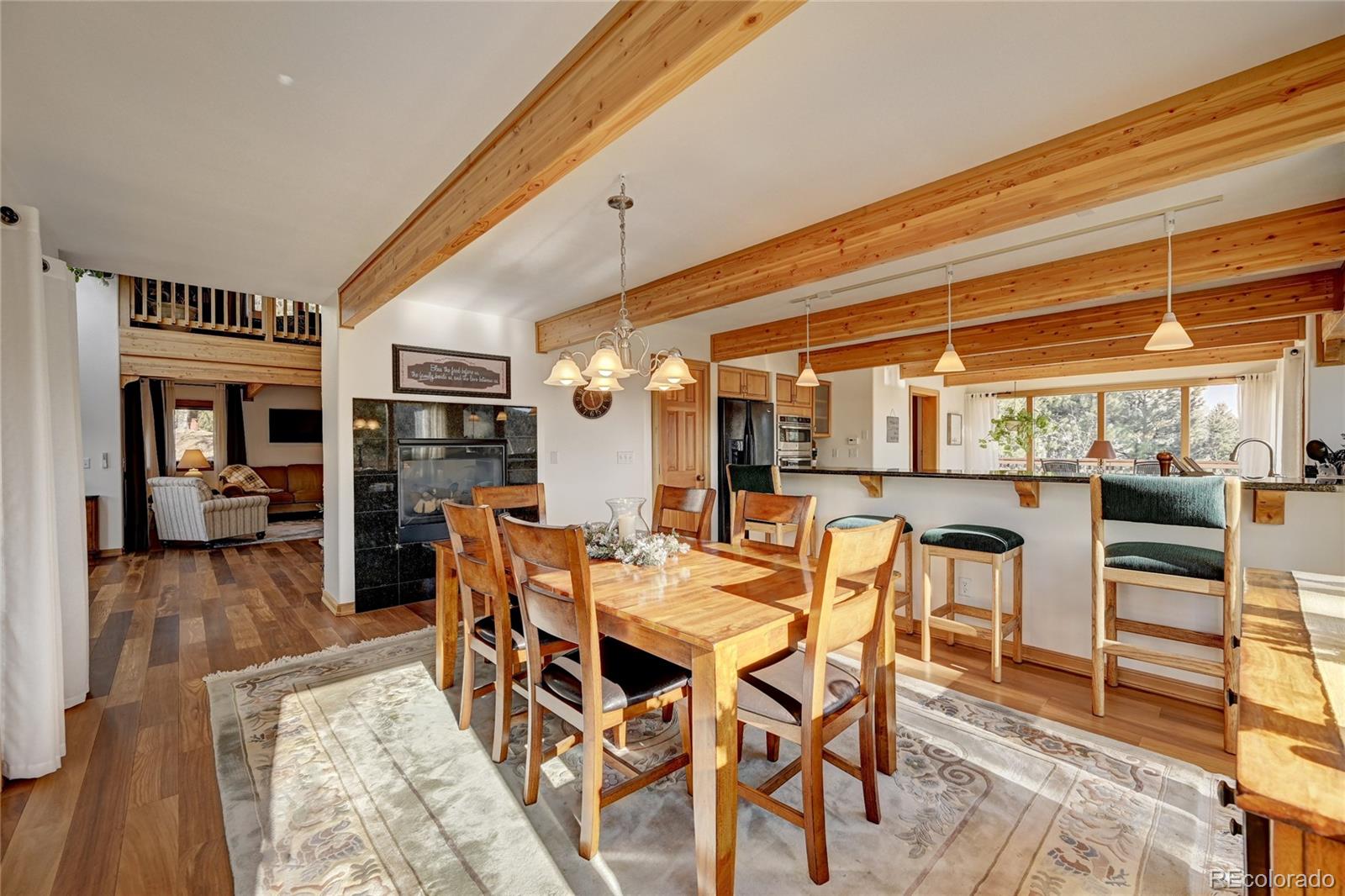 27164 Sun Ridge Drive Evergreen, CO 80439 - Photo 11 of 40 a dining room with furniture and wooden floor