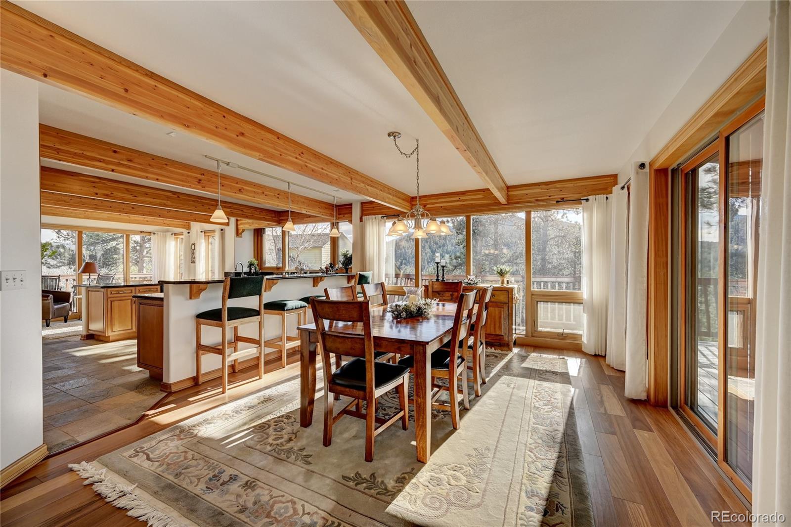 27164 Sun Ridge Drive Evergreen, CO 80439 - Photo 12 of 40 a dining room with furniture and wooden floor